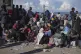 Displaced Palestinians gather with their belongings near a r