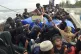An Acehnese man distribute food to Rohingya refugees on a bo