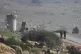 Israeli soldiers stand guard at a checkpoint where the milit