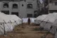 A man walks between tents for displaced Palestinians next to
