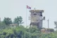 A soldier stands at a North Korean military guard post flyin