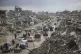Palestinians walk along a street amid widespread destruction