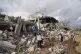 Members of the Dwaima family stand on the rubble of their ho