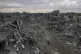 People walk amid the destruction caused by the Israeli milit