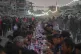 Palestinians sit at a large table surrounded by the rubble o