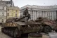 A boy sits atop a displayed damaged Russian tank in central 