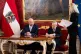 Austrian President Alexander Van der Bellen (centre) signs p