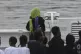 Migrants stand on the deck of the Italian Coast Guard ship D