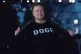 Elon Musk flashes his t-shirt that reads ‘DOGE’ to the m