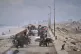 Displaced Palestinians, carrying their belongings, wood and 