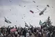 Confetti and flowers are dropped from a military helicopter 