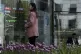 People stand outside a brokerage house as an electronic boar