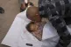 A relative kisses the body of Ahlam Seiam, who was just days