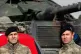 Turkish Army officers stand next to their tank at a staging 