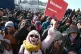 A woman hold a sign which reads: 