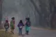 Five children make their way to school on the outskirts of G