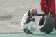 Fernando Alonso examines the wheel of his car after a crash