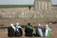 Palestinian women sit in front of an Israeli military positi
