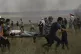 Palestinian medics evacuate a wounded youth near Israel's bo