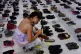 A woman places one of the hundreds of shoes in memory of tho