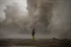 A woman photographs the Mediterranean sea as the waves hit t