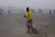 A sweeper cleans as smog envelops the area and reduces visib