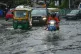 Vehicles move through a waterlogged street in Kolkata, India