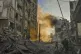 A man runs for cover as a smoke raises in the background fol