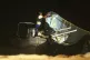 Police help move a boat that was carrying decomposing corpse
