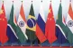 Staff worker stands behinds national flags of Brazil, Russia