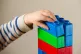 A preschool age child playing with plastic building blocks, 