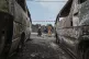Residents walk by charred vehicles in Goma, Democratic repub