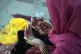 A woman has her hands painted with traditional henna as she 