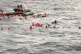 Refugees fall in the sea after the floor in their boat rips 