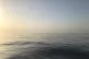 Two refugee boats appear as small dots on the horizon as the