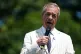 Reform UK leader Nigel Farage speaking on top of a double de