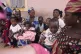 Women and their children wais during an event on how to prep