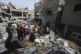 Palestinians look at the destruction after an Israeli strike