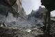 Palestinians look at the aftermath of the Israeli bombing in