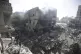 Palestinians look at the aftermath of the Israeli bombing in