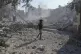 A Palestinian boy walks past the rubble of a school destroye