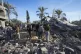 Palestinians look at home destroyed by an Israeli strike lat