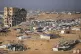 A tent camp for displaced Palestinians is set up amid destro