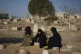 Fatma Abu Awad and her daughter Malak pray in a graveyard wh