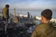 Palestinians inspect the site of an Israeli army strike earl