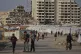 Palestinians walk next to a tent camp for displaced by the I