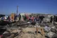 Palestinians inspect the remains of a displacement tent hit 
