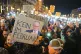 Protesters hold up lights on the street in front of the CDU 