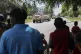 Residents look at armoured vehicles carrying Kenyan police o