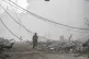 WASTELAND: A man walks as smoke rises from destroyed buildin